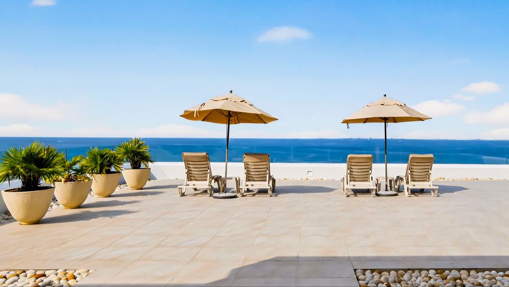 Rooftop sun deck with umbrellas and loungers over the ocean