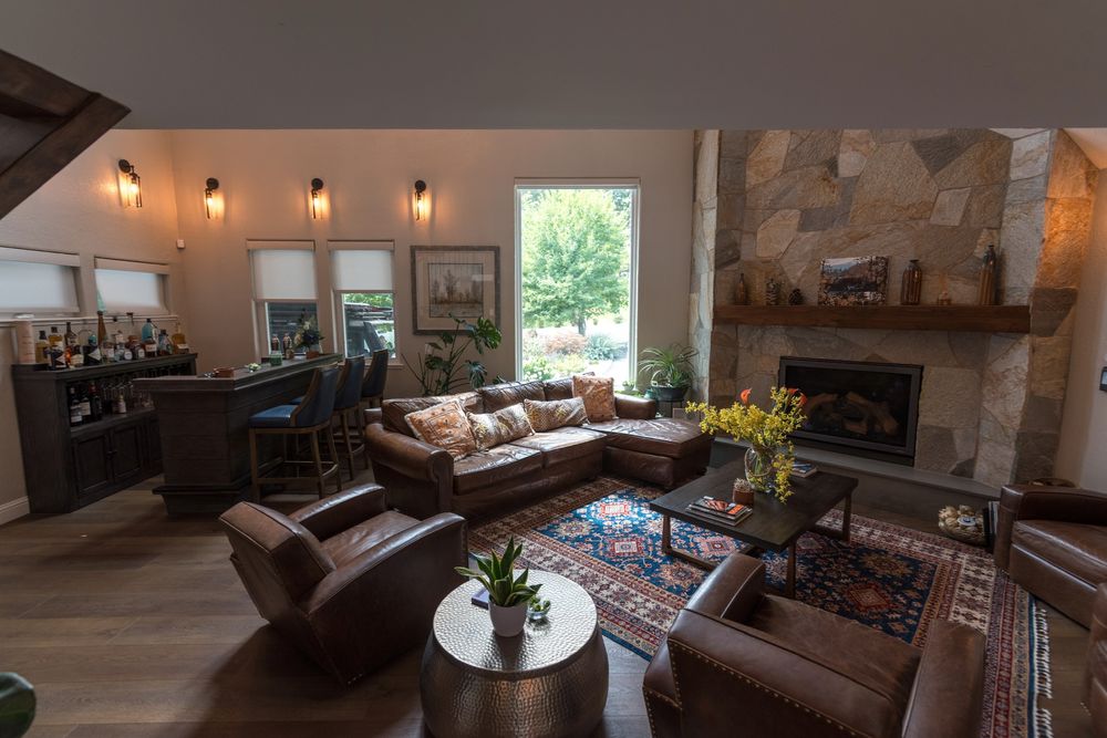 Great room with two-story stone fireplace, leather sofas and bar