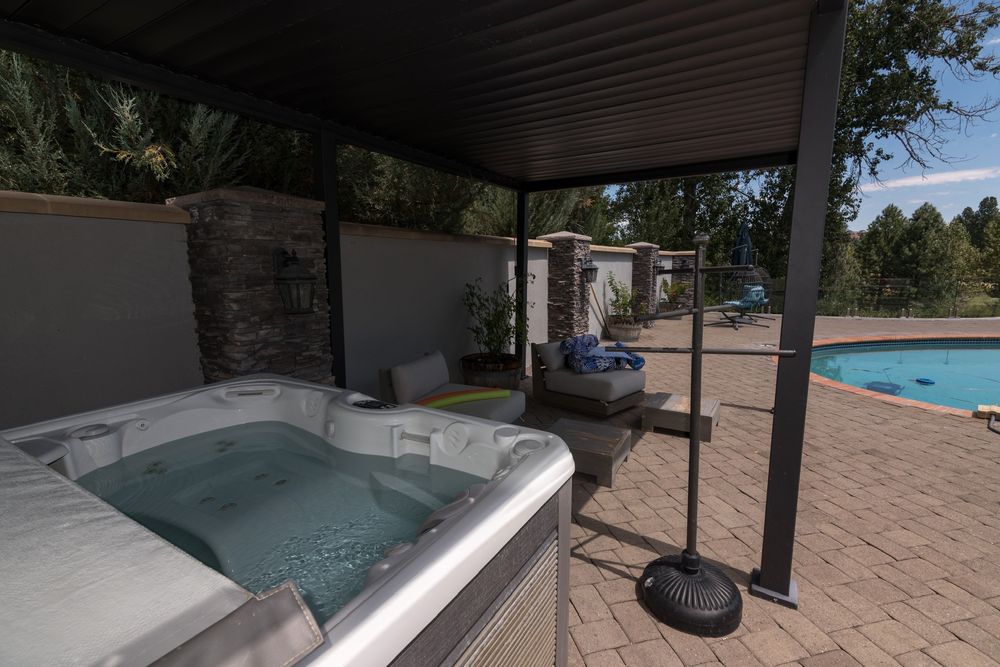 Hot tub under the covered pergola beside the pool