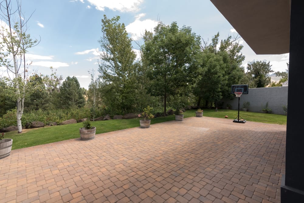 Paved sport court with basketball hoop and lawn